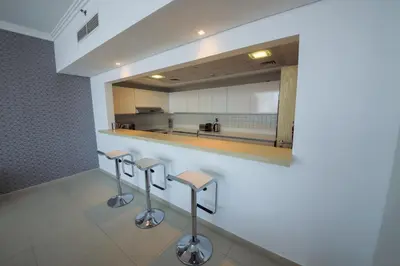 a kitchen with two stools and a mirror at Stunning 5* 4BR-Oceanfront-Apartment in Dubai