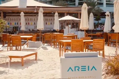a group of tables and chairs and umbrellas at Stunning 5* 4BR-Oceanfront-Apartment in Dubai