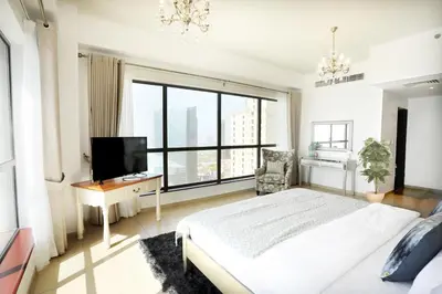a bedroom with a white bed and a large window at Luxury Casa - Grand Sea View Apartment JBR Beach 2BR in Dubai