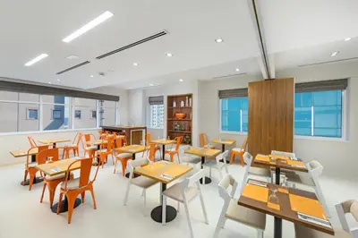 a dining room with tables and chairs and windows at Citymax Hotel Al Barsha in Dubai