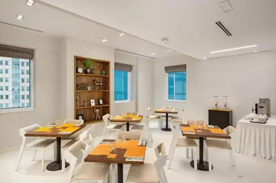 a dining room with tables and white chairs at Citymax Hotel Al Barsha in Dubai