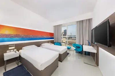 a hotel room with two beds and a flat screen tv at Citymax Hotel Al Barsha in Dubai