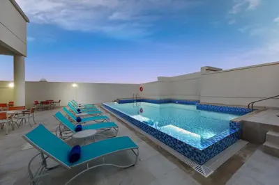 a pool with blue tables and chairs in a building at Citymax Hotel Al Barsha in Dubai