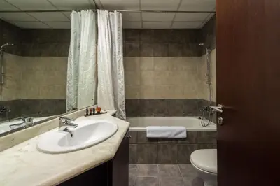 a bathroom with a sink and a tub and a toilet at EDEN'S Homes & Villas - KG Tower in Dubai