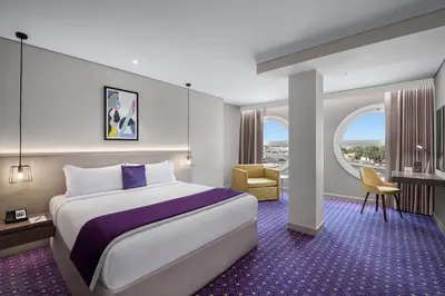 a hotel room with a large bed and a desk at Leva Hotel and Suites, Opposite Downtown in Dubai