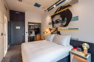 a hotel room with a bed and a painting on the wall at Studio One Hotel in Dubai