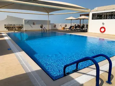 a large swimming pool with blue water in a building at Al Khoory Executive Hotel, Al Wasl in Dubai