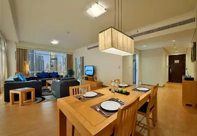 a kitchen and living room with a table and chairs at Oaks Liwa Heights Hotel Suites in Dubai