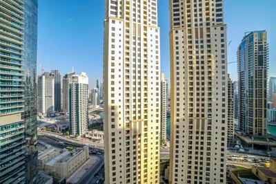 two tall white skyscrapers in a large city at Royal Beach Residence in Dubai