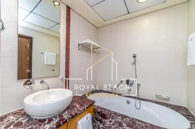 a bathroom with a sink and a bath tub at Royal Beach Residence in Dubai
