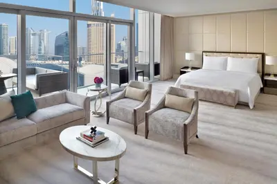 a hotel room with a bed and a couch and chairs at Address Dubai Mall in Dubai