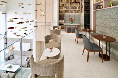 a lobby with tables and chairs and tablesearcher at Address Sky View, Downtown Dubai in Dubai