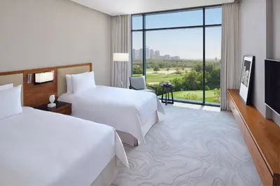 a hotel room with two beds and a large window at Vida Emirates Hills in Dubai