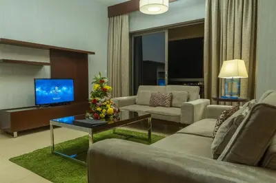 a living room with two couches and a television at SUHA JBR Hotel Apartments in Dubai