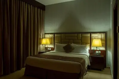 a hotel room with a large bed with two lamps at SUHA JBR Hotel Apartments in Dubai
