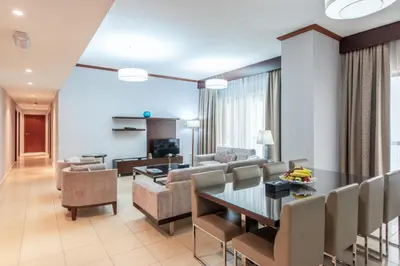 a living room and dining room with a table and chairs at SUHA JBR Hotel Apartments in Dubai
