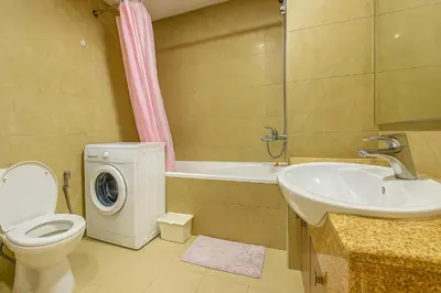 a bathroom with a toilet and a sink and a washing machine at Classy Studios for Ladies in Dubai, Marina فتيات فقط in Dubai