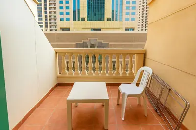 a small table and a chair in a balcony at Classy Studios for Ladies in Dubai, Marina فتيات فقط in Dubai