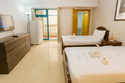 a hotel room with two beds and a television at Classy Studios for Ladies in Dubai, Marina فتيات فقط in Dubai