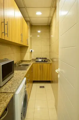 a small kitchen with a washer and dryer at Classy Studios for Ladies in Dubai, Marina فتيات فقط in Dubai