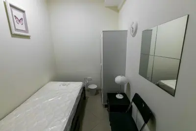 a small room with a bed and a mirror at Small Budget Rooms for 'girls' only in Dubai, Marina in Dubai