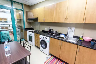 a kitchen with a sink and a washing machine at Small Budget Rooms for 'girls' only in Dubai, Marina in Dubai