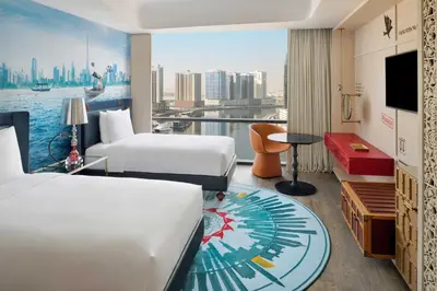 a hotel room with two beds and a view of the city at Hotel Indigo Dubai Downtown by IHG in Dubai