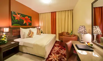 a hotel room with a bed and a desk at Abidos Hotel Apartment Dubai Land in Dubai