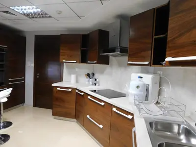 a kitchen with wooden cabinets and a sink at Luton Vacation Homes - The Marina Torch - Sea view - 64AB07 in Dubai