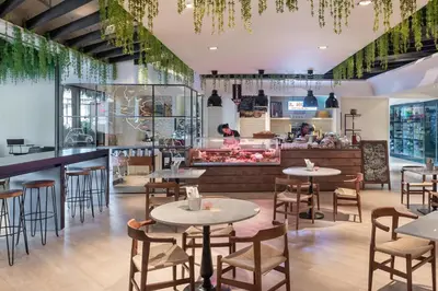 a restaurant with tables and chairs and a counter at JA Ocean View Hotel, Jumeirah Beach Dubai in Dubai