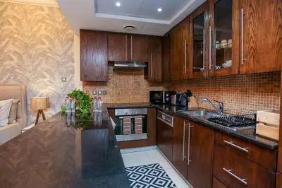 a kitchen with wooden cabinets and a counter top at Prime Retreats - Downtown Dubai in Dubai