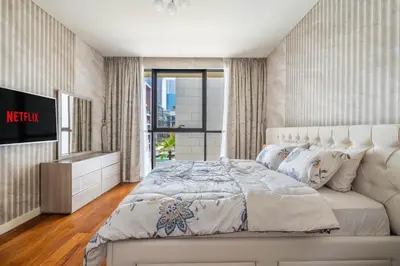 a bedroom with a large white bed and a television at City walk apartment Specter in Dubai