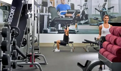 a woman and a boy in the gym at Millennium Plaza Downtown Suites in Dubai