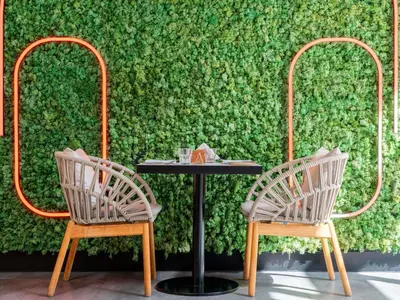 two chairs and a table in front of a green wall at ibis Dubai World Trade Centre in Dubai