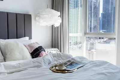 a bed with a tray with a book and a cup on it at Wow! Super Luxury Apartment in Dubai Marina - 1BR RO in Dubai