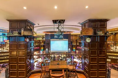 a library with a table and a tv in a room at Roda Al Murooj Residences in Dubai