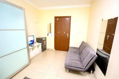 a living room with a chair and a television at comfortable Rooms For Girls in Marina Dubai, the best offer in Dubai