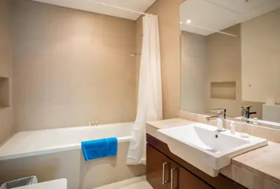 a bathroom with a sink and a tub and a toilet at New Arabian -Panorama 2 BR Full Golf course View in Dubai
