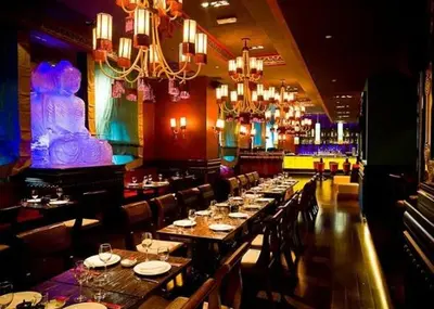 a restaurant with long tables and chairs and chandeliers at Downtown Al Bahar Apartments in Dubai