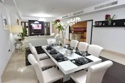 a dining room and living room with a white table and chairs at Jbr penthouse with terrace pool in Dubai