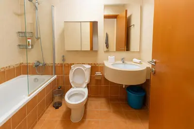 a bathroom with a toilet and a sink and a tub at Deluxe Studio for Rent at Marina View Towers in Dubai