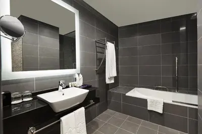 a bathroom with a sink and a bath tub at Park Regis Business Bay in Dubai