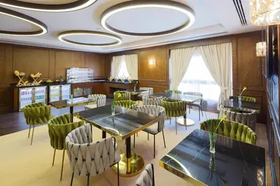 a restaurant with tables and chairs in a room at Barcelo Al Jaddaf, Dubai in Dubai