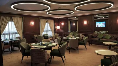 a dining room with tables and chairs and a tv at Barcelo Al Jaddaf, Dubai in Dubai