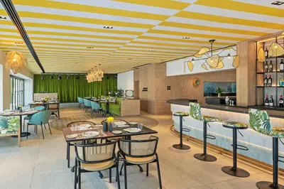 a restaurant with tables and chairs and a bar at Barcelo Al Jaddaf, Dubai in Dubai