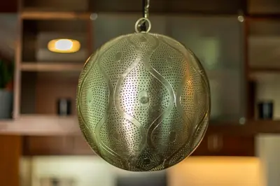 a green glass ornament hanging from a chain at AUBERGE Luxury 2BR Full Burj Khalifa and Fountain View in Dubai