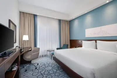 a hotel room with a large bed and a television at Hampton By Hilton Dubai Al Barsha in Dubai