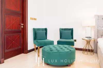 two green chairs and a ottoman in a living room at LUX - The Ocean Pearl Villa in Dubai