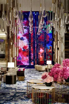 a lobby with tables and chandeliers and a painting at Atlantis The Royal in Dubai