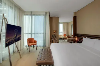 a hotel room with a large bed and a chair at Paramount Hotel Dubai in Dubai